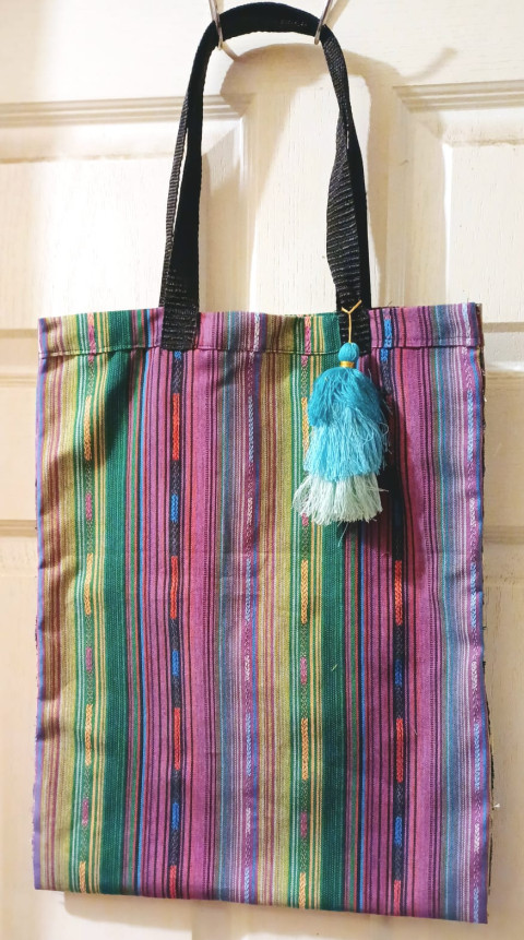 Bolsa de tela con diseños de color y detalles en hilos de color combinados