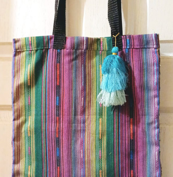 Bolsa de tela con diseños de color y detalles en hilos de color combinados