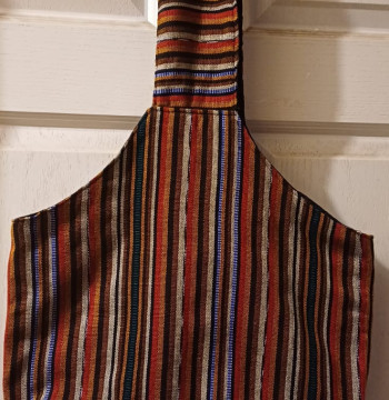 Bolsa de tela con diseños lineales en tonos tierra con cinta ancha .