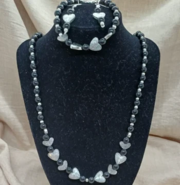 Set de collar, aretes y pulsera con corazones color gris.