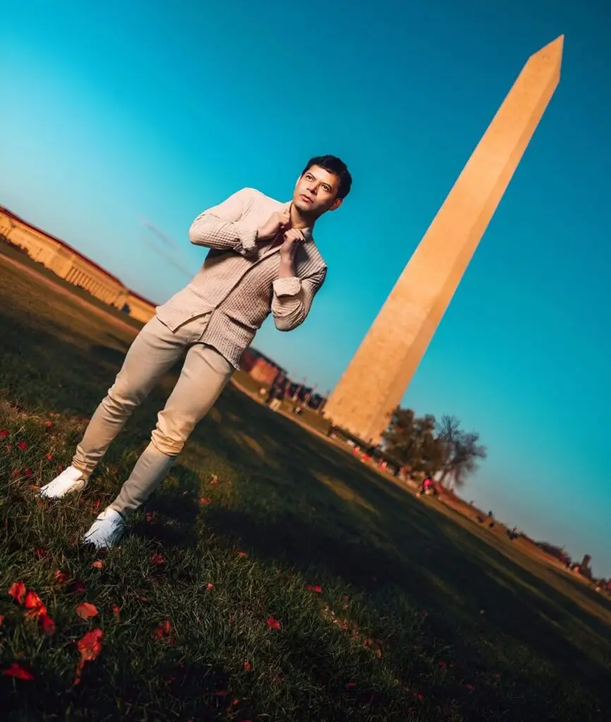 El estilista y migrante guatemalteco Sergio Arévalo sigue adelante en su ruta de éxito en el mundo de la belleza pero sobre todo en el compartir lo que tiene con los más necesitados. Fotografía con la célebre Aguja de Washington D.C. durante su estadía reciente. – SoyMigrante.com REVISTA – SoyMigrante.com REVISTA