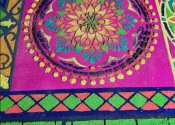 Los diseños geométricos pueden adquirir enorme complejidad y requieren de hasta 10 moldes para ser completados. Quienes los elaboran se colocan sobre tablas sostenidas con bloques para poder trabajar por encima e ir coloreando con aserrín la forma prevista, El aserrín con los tintes se prepara desde muchas semanas antes, para que su color no varíe al secarse. (Foto Michelle Gonzalez)