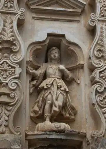 Ángeles flanquean los lados del atrio interior de Santa Clara. Nótese el estilo de las columnas a los lados, de tipo serliano. Por eso este frontispicio es una de las mejores muestras del barroco guatemalteco.