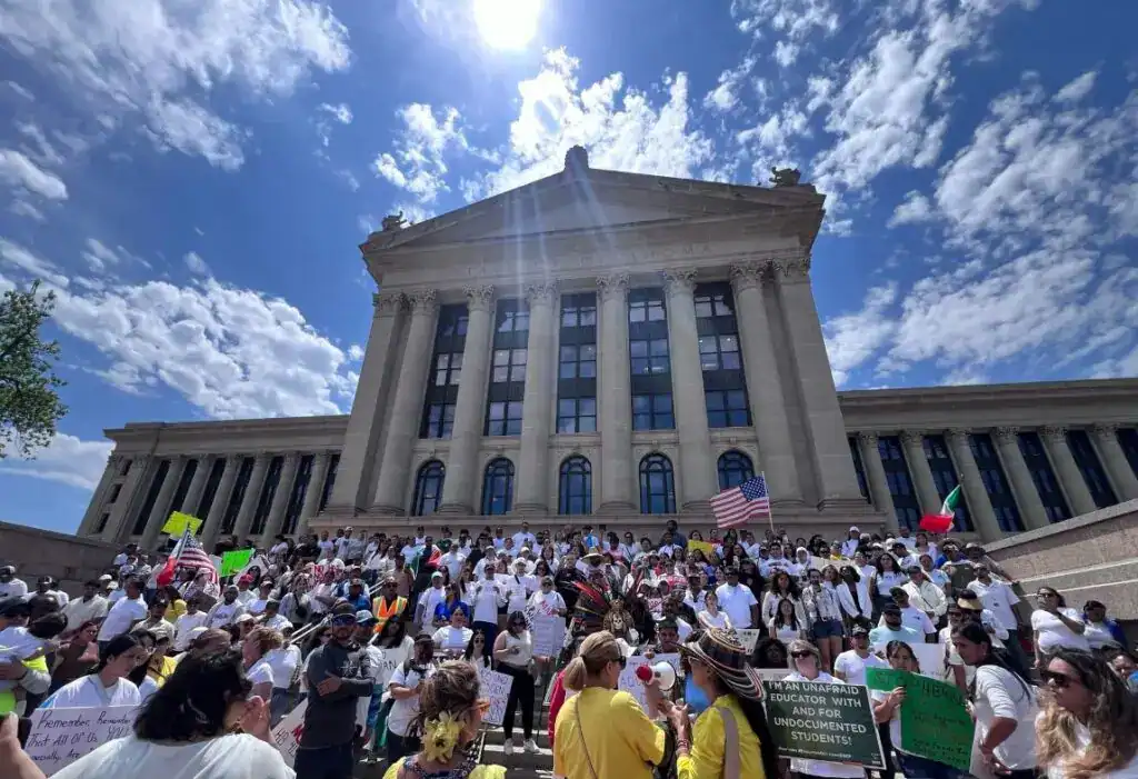 Manifestación de inmigrantes frente a un edificio gubernamental, promoviendo derechos y apoyo para estudiantes inmigrantes en EE.UU. y México, en el contexto de la revista SoyMigrante.com REVISTA.