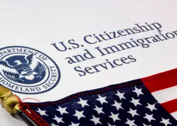 Documentación de inmigración y ciudadanía de EE. UU. en un formulario con la bandera de Estados Unidos.