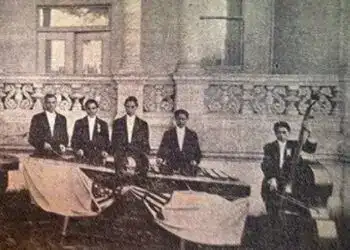Retrato de músicos mexicanos en uniforme formal tocando instrumentos tradicionales en un evento histórico, representando la cultura y el talento artístico en México.