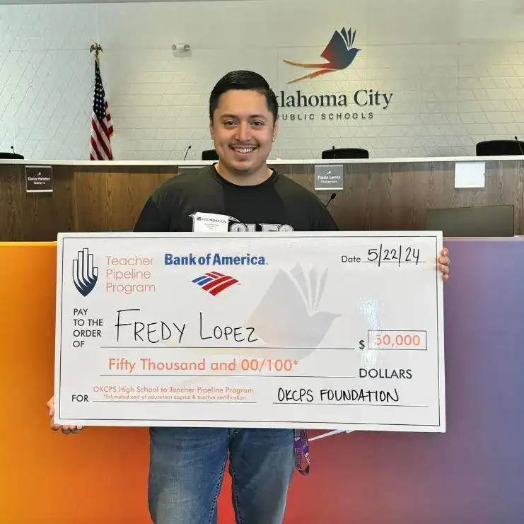Fredy López graduado de High School en Oklahoma obtuvo beca – SoyMigrante.com REVISTA Premio de beca por $50,000 a Fredy Lopez en la escuela OKCPS, evento destacado de solidaridad y apoyo a migrantes en Oklahoma City, con fondo de aula y logotipo de la ciudad.