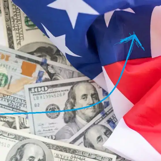 Dinero en billetes de dólares y bandera de EE.UU., símbolo de migración y economía internacional.
