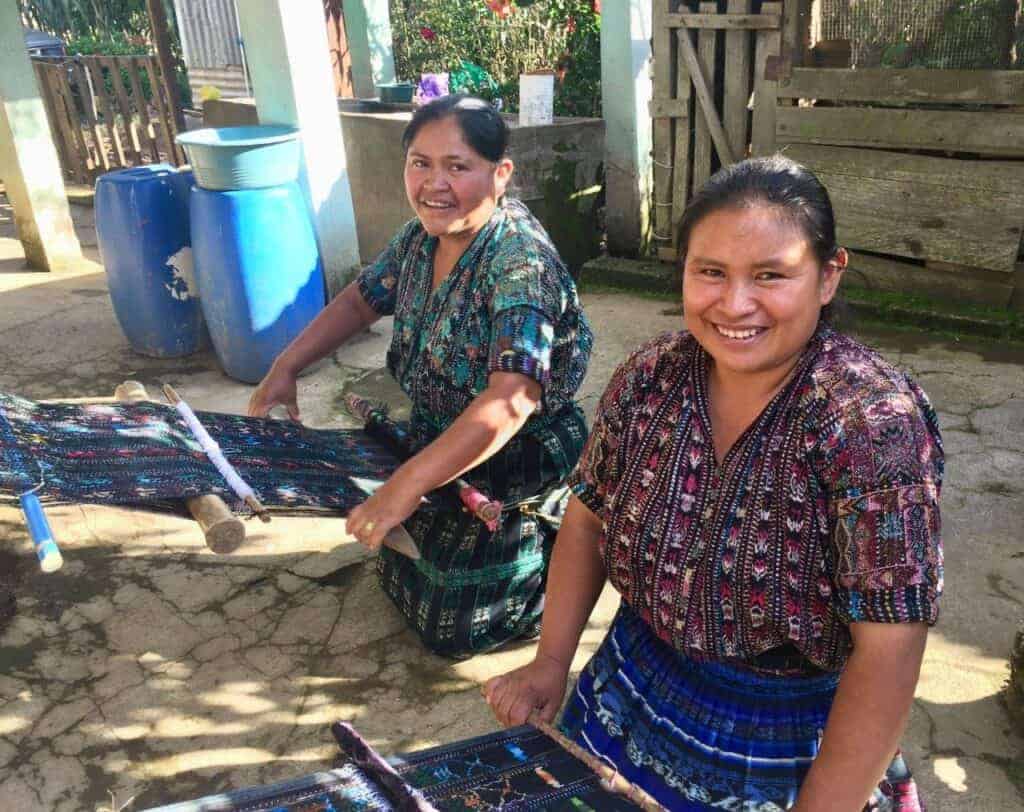 Bill y Jacine, los fundadores de Quetzal Project, compran textiles en las comunidades para luego venderlos en EE.UU. a fin de generar oportunidades y a la vez financiar el pago de los maestros. – SoyMigrante.com REVISTA