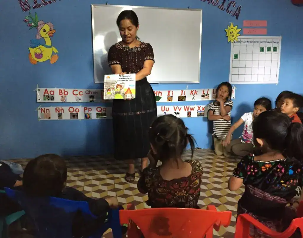 Niña enseñando cuento a niños en aula multicultural de educación infantil en México. – SoyMigrante.com REVISTA