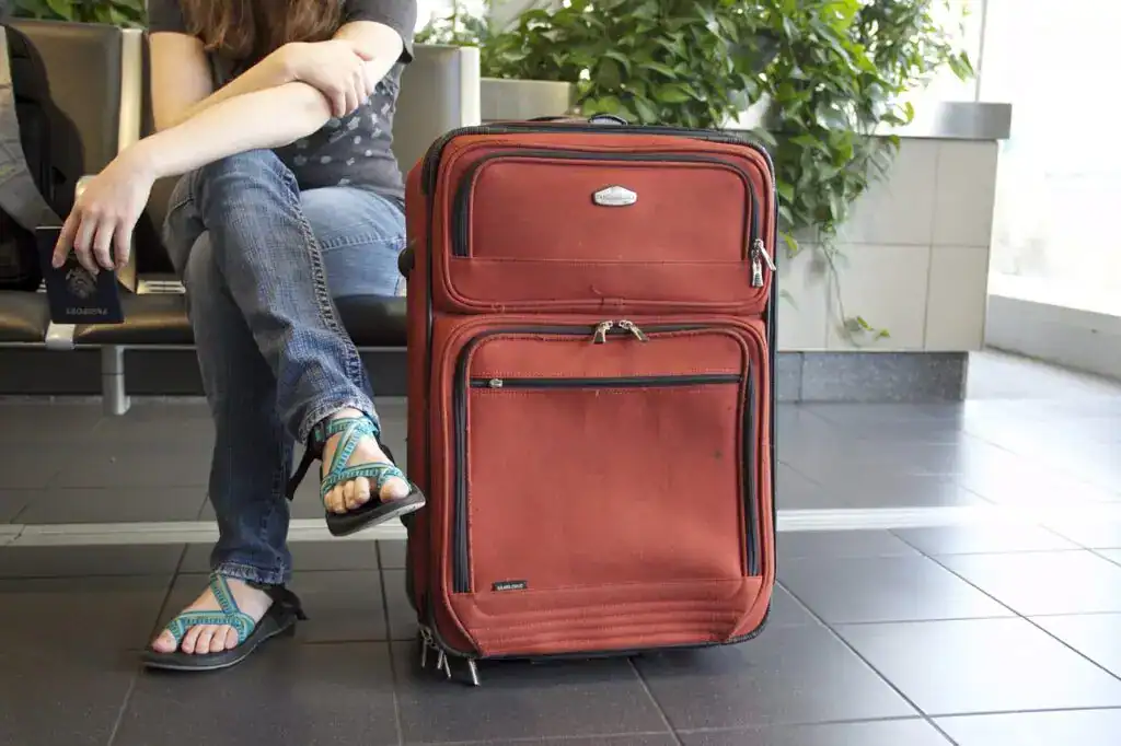 Viajera con maleta en aeropuerto, mujer con equipaje de mano y mochila, esperando en aeropuerto, viaje internacional, turismo, destino turístico, pasaporte, maleta roja, vacaciones, ocio, turismo de aventura, travel, transbordo, aeropuerto, condiciones de viaje, aventura, destino, temporada alta, viaje de negocios, viaje de placer, transporte, movilidad, horas de vuelo, aeropuerto internacional, experiencia de viaje, destino turístico, aventura, aventura y exploración, experiencia de viaje, formulación de viaje, movilidad, transporte, transporte internacional, gestión del alquiler de equipajes, protección de equipajes, logística de movilidad, experiencia de viaje, equipaje, maletas, aeropuerto, viajes, destino, turismo, aventura.