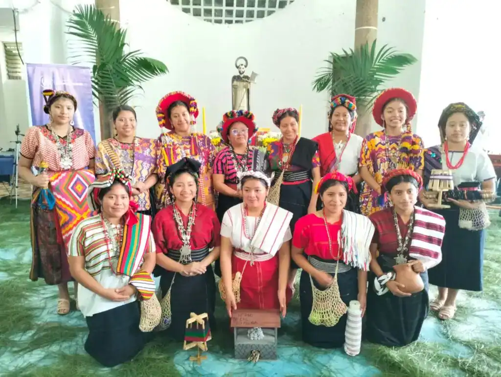 Diversas mujeres y niñas mexicanas vestidas con trajes tradicionales indígenas en una celebración cultural, promoviendo identidad y patrimonio.