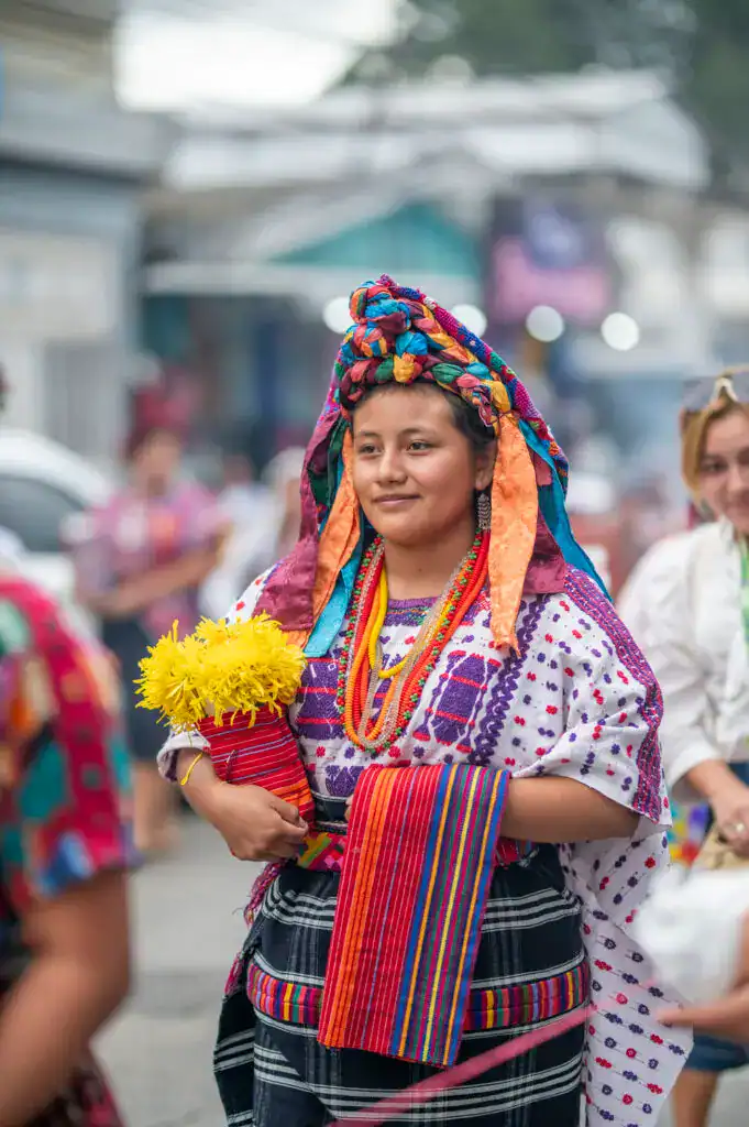 Diversa mujer indígena de Mesoamérica vestida con trajes tradicionales coloridos en una celebración cultural en México. Mujeres en festivales tradicionales, identidad cultural y orgullo indígena. – SoyMigrante.com REVISTA