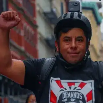 Gustavo Ajche, guatemalteco migrante lidera a los repartidores de comida en Nueva York, agrupados en la organización Los Deliveristas Unidos – SoyMigrante.com REVISTA Hombre joven con casco de bicicleta en calle urbana, mostrando actitud positiva y segura, promoviendo la movilidad y el activismo social en comunidades urbanas en América Latina. – SoyMigrante.com REVISTA
