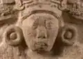 Arte prehispánico en piedra con detalladas esculturas de rostro humano y motivos geometricos, representando la riqueza cultural de las civilizaciones antiguas en Mesoamérica. – SoyMigrante.com REVISTA