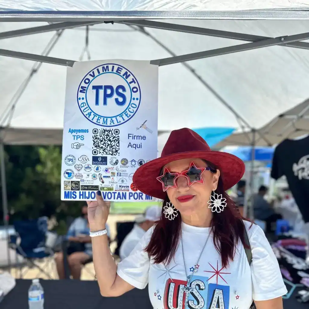 Manifestante apoyando la causa TPS en un evento político en un puesto al aire libre en Estados Unidos.