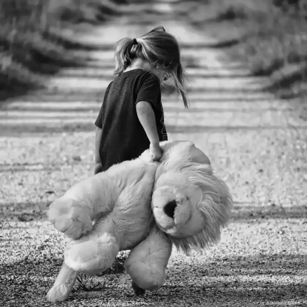 Perro de raza Golden Retriever con niña pequeña caminando por sendero de tierra, imagen en blanco y negro, enfoque en amistad y compañía entre niños y mascotas. – SoyMigrante.com REVISTA