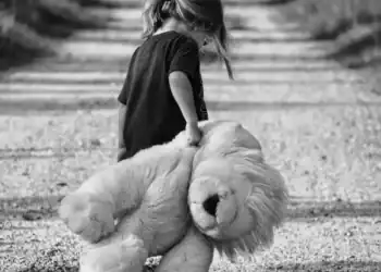 Consejos para ayudar a enfrentar el duelo migratorio en niños2 – SoyMigrante.com REVISTA Perro de raza Golden Retriever con niña pequeña caminando por sendero de tierra, imagen en blanco y negro, enfoque en amistad y compañía entre niños y mascotas. – SoyMigrante.com REVISTA