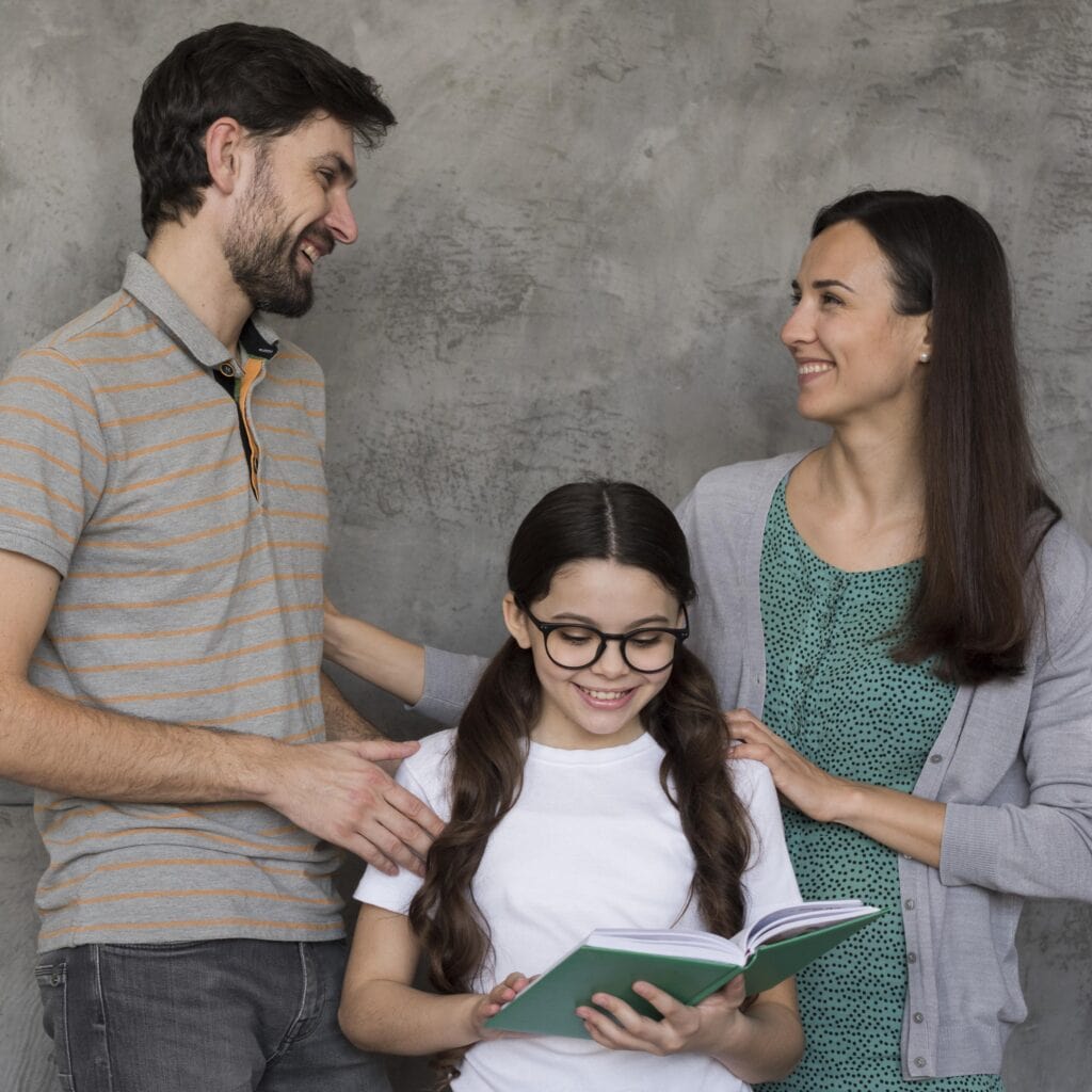 Amigos y familia celebrando el logro de una niña con libro, enfoque en comunidad, apoyo familiar, educación y cultura para difusión en revista SoyMigrante.com. – SoyMigrante.com REVISTA