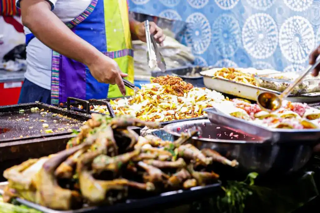 Sabores de la gastronomía mexicana en una feria callejera, con diversos platillos tradicionales y colores vibrantes. – SoyMigrante.com REVISTA