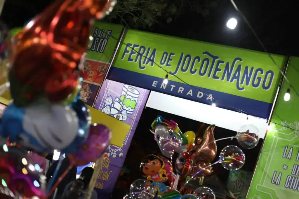 Junta del recuento de la Feria de Jocotenango con entradas y globos de colores en la noche. – SoyMigrante.com REVISTA