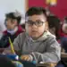 Estudiante en aula escolar, niño con gafas, atención y concentración en clase, educación, aprendizaje, escuela primaria.