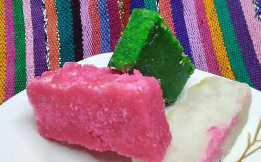 Coloridas tazas de azúcar tradicional mexicana en diferentes colores, decoradas y con fondos tejidos de colores vivos, representando la cultura mexicana. – SoyMigrante.com REVISTA