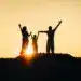 Familia en silhouette disfrutando del atardecer, simbolizando unión y esperanza, en una imagen inspiradora sobre migración y comunidad en SoyMigrante.com REVISTA.