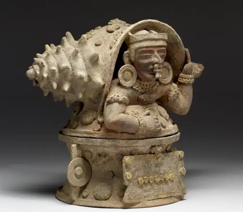 Guerrero olmeca de piedra, con detalles en orejeras y tocado, pieza arqueológica de la cultura prehispánica mexicana. – SoyMigrante.com REVISTA