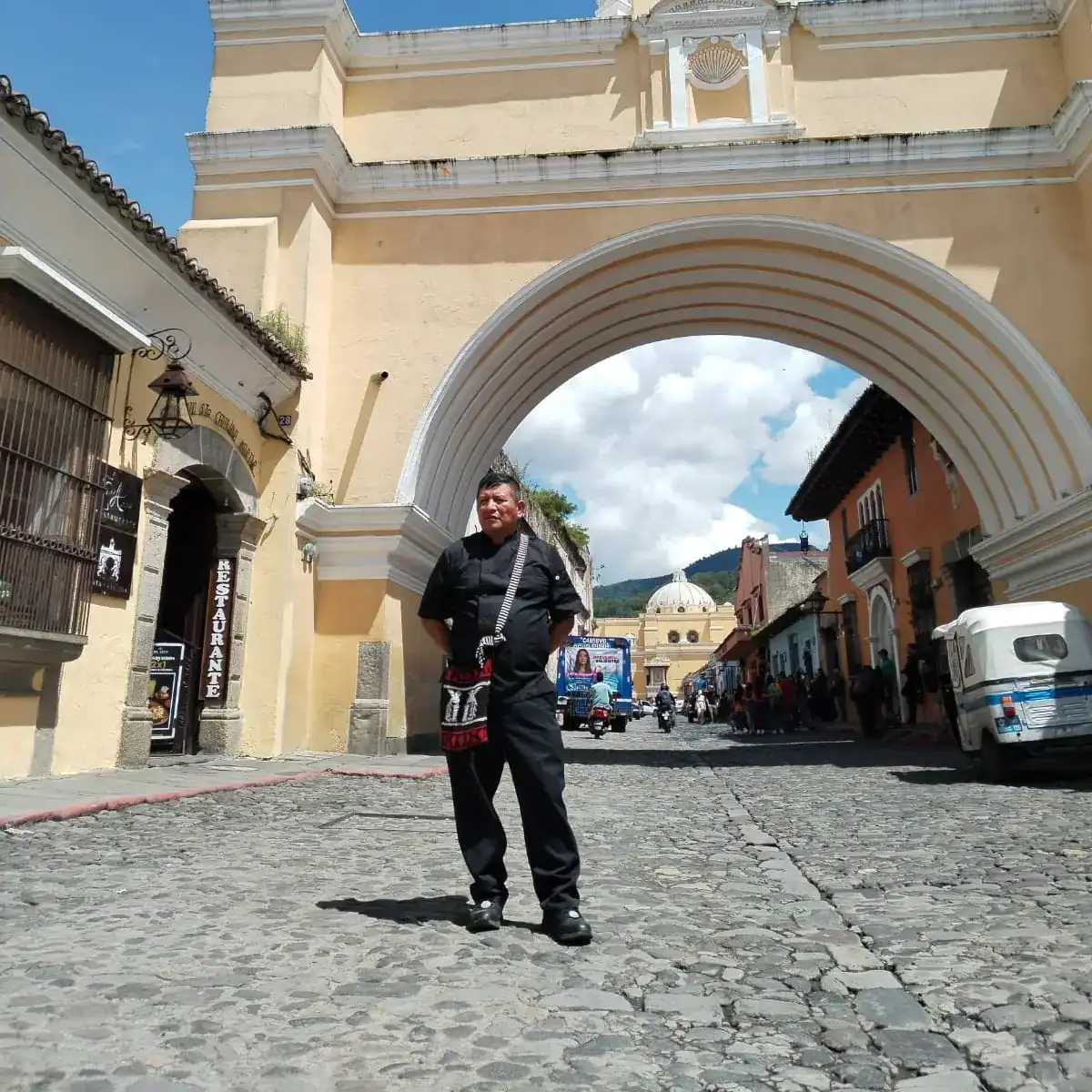 Puente histórico y arquitectura colonial en Guatemala, ambiente urbano y cultural en Antigua Guatemala, turismo y tradiciones en Centroamérica, imagen representativa de la comunidad migrante.
