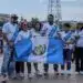 Diversos migrantes latinoamericanos con banderas de Guatemala en un evento cultural, promoviendo comunidad y identidad en el contexto de la migración y la integración social.