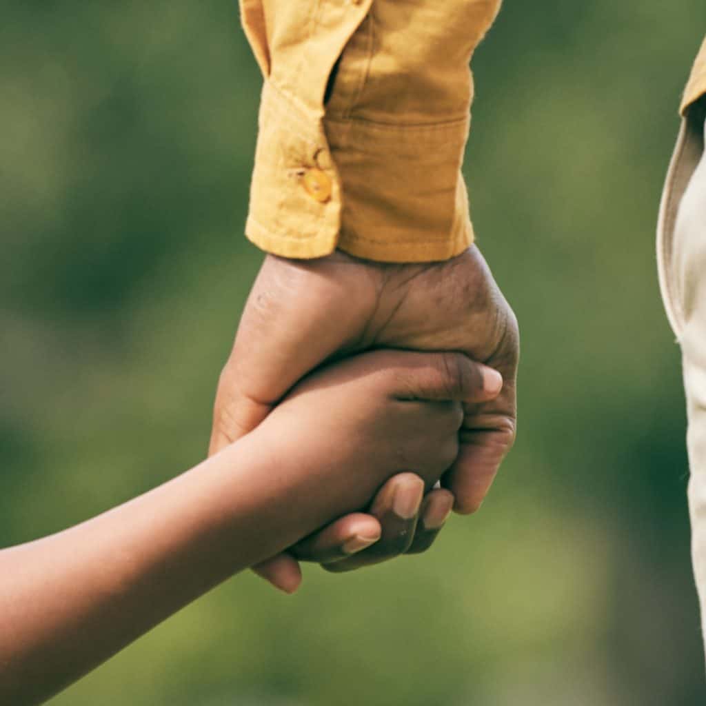 Manos entrelazadas de diferentes generaciones, simbolizando unión y apoyo en la comunidad migrante. – SoyMigrante.com REVISTA