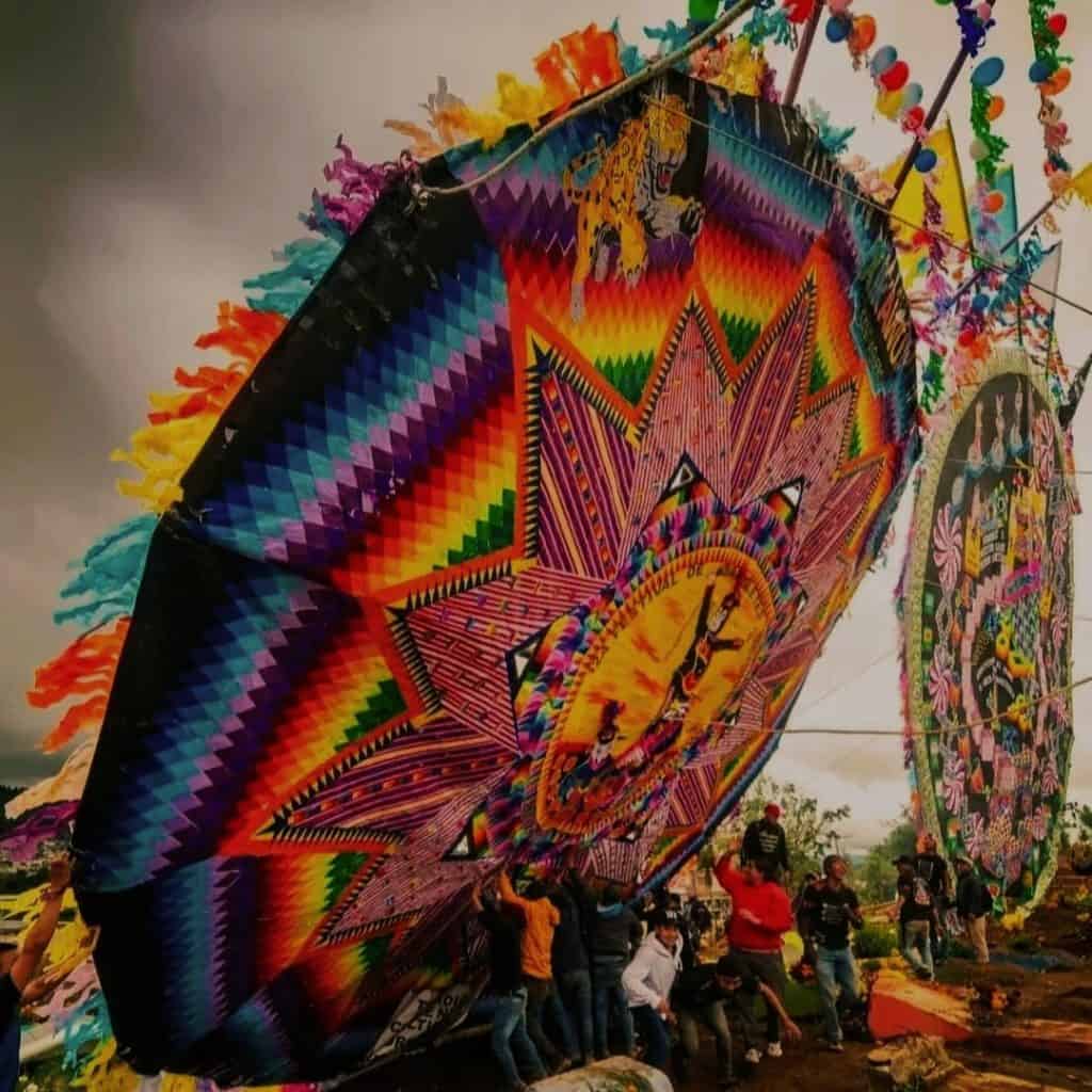 Banderas y faroles tradicionales en una celebración cultural mexicana, llenas de color y significado, representando la comunidad y el orgullo indígena en un evento festivo.