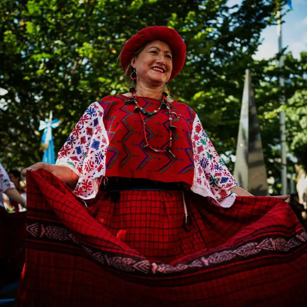 María Sandoval Grupo Quetzal soy migrante – SoyMigrante.com REVISTA Colaboradora con traje tradicional mexicano durante celebración cultural con árboles de fondo en la revista SoyMigrante.com REVISTA. – SoyMigrante.com REVISTA