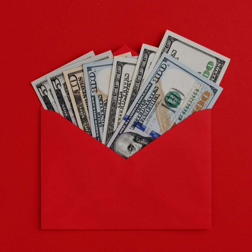 Bolsillo rojo con billetes de dólares, símbolo de finanzas y economía para artículos sobre inmigrantes y recursos económicos en SoyMigrante.com REVISTA. – SoyMigrante.com REVISTA