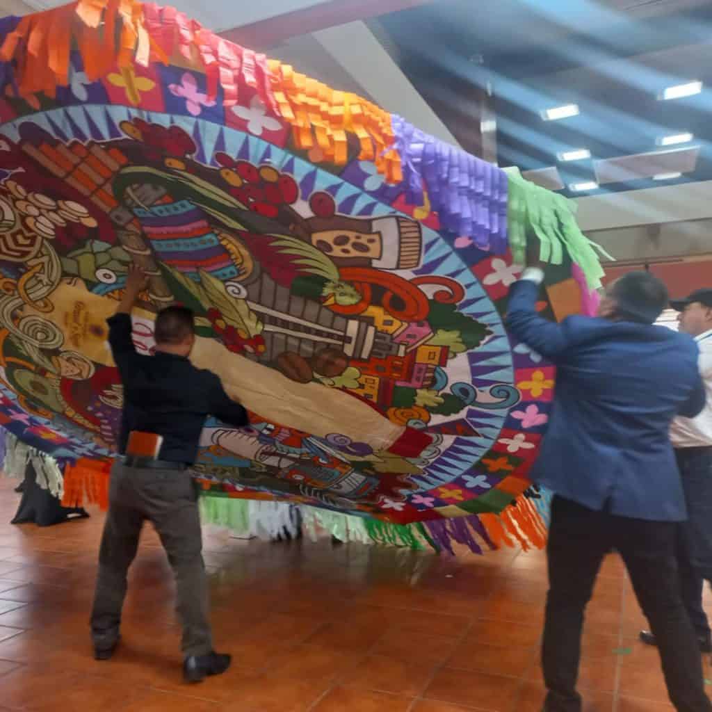 Colorido evento cultural con draga tradicional y gente participando, destacando la identidad y festividades mexicanas en una feria cultural. – SoyMigrante.com REVISTA