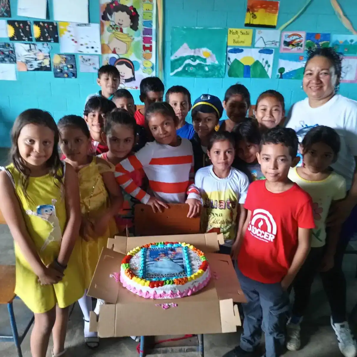 dia del niño 2024 – SoyMigrante.com REVISTA Torta de cumpleaños con niños en aula escolar, celebración en comunidad educativa, actividades culturales y sociales, Revista SoyMigrante.com, integración y alegría infantil.