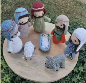 Niños con figuras de ganchillo de la historia de Navidad, incluyendo a María, José, el Niño Jesús, oveja, burro y otros personajes bíblicos hechos a mano.