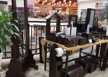 Espejo de pie de madera, artículos de decoración y accesorios para baños en un espacio comercial. Muestra productos de estética, mobiliario y artículos de higiene personal.