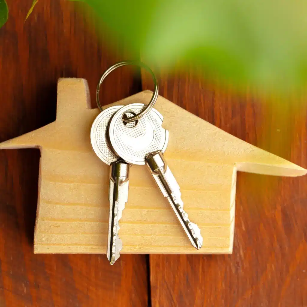 Llaves sobre una figura de madera en forma de estrella, simbolizando la vivienda y las oportunidades para migrantes. Imagen que representa temas de migración, inclusión y acceso a vivienda para comunidad migrante.