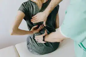 Mujer recibiendo atención médica por un problema de salud en el pecho, en consulta clínica, atención médica especializada, imagen que refleja temas de salud, bienestar y servicios para migrantes.