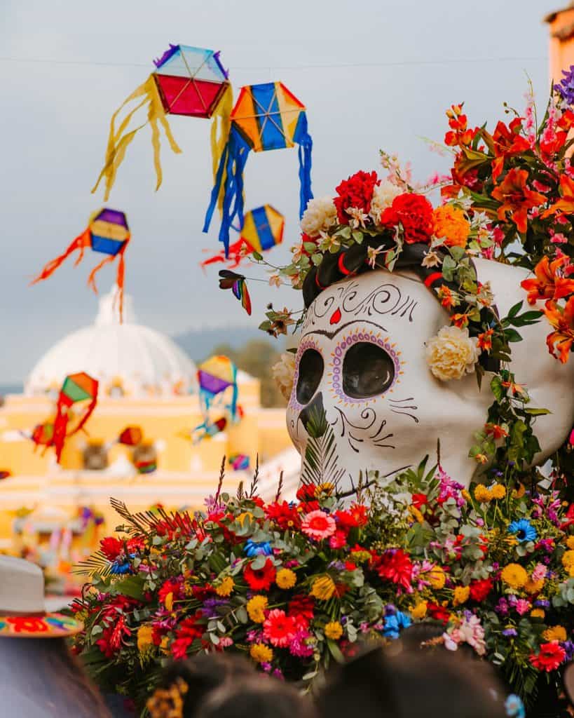 Colorido altar de Día de los Muertos con calavera decorada y flores en un evento cultural mexicano, resaltando tradiciones, celebración y arte popular en México.