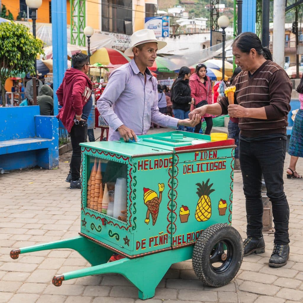 Vendedor de helados y nieves artesanales en mercado tradicional, promoción de productos mexicanos y cultura popular en el contexto de la comunidad inmigrante. – SoyMigrante.com REVISTA