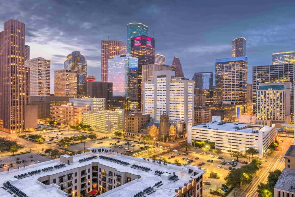 Moderno skyline de Houston, Texas, con rascacielos iluminados al atardecer, reflejando el crecimiento urbano y la importancia de las ciudades en la migración y comunidades latinas en EE.UU. – SoyMigrante.com REVISTA
