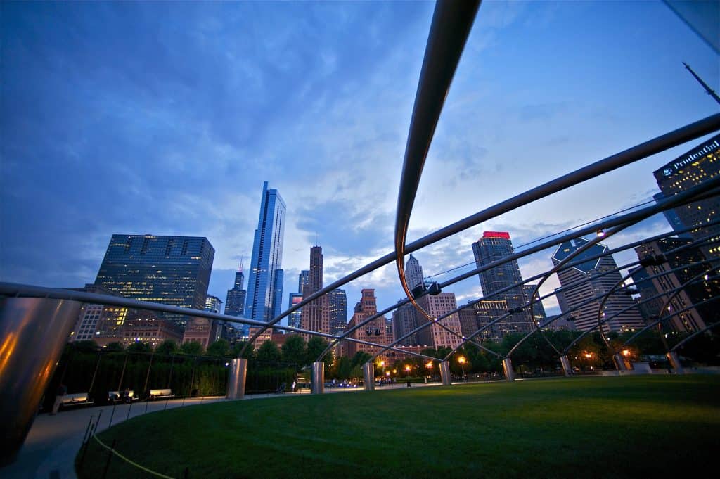 Cielos azules y rascacielos de Chicago con arquitectura moderna en la ciudad, vista desde Millennium Park durante el atardecer.