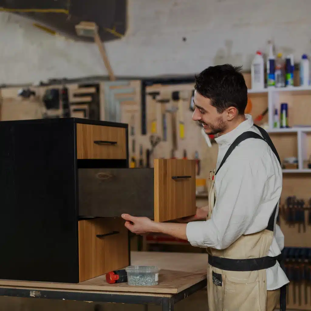 Armario de madera en taller de carpintería, joven hombre trabaja con creatividad y pasión en proyecto de mobiliario.