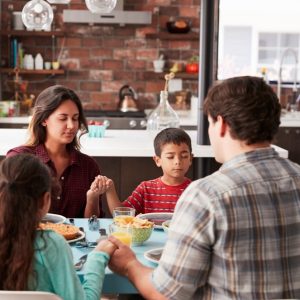 Familia cenando en cocina moderna, valores familiares, comida casera, unión familiar, ambiente cálido y acogedor, comunidad hispana, tradición cultural, celebración familiar, estilo de vida saludable, diversidad cultural. – SoyMigrante.com REVISTA