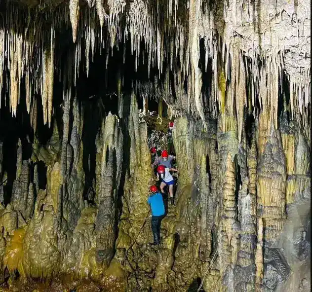 Exploradores en una cueva de estalactitas y estalacmitas en una cueva turística, aventuras de turismo de naturaleza y espeleología. – SoyMigrante.com REVISTA