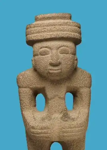 Arte prehispánico de Mesoamérica, escultura en piedra con figura humana y accesorios tradicionales, representando cultura indígena y tradiciones ancestrales en México. – SoyMigrante.com REVISTA