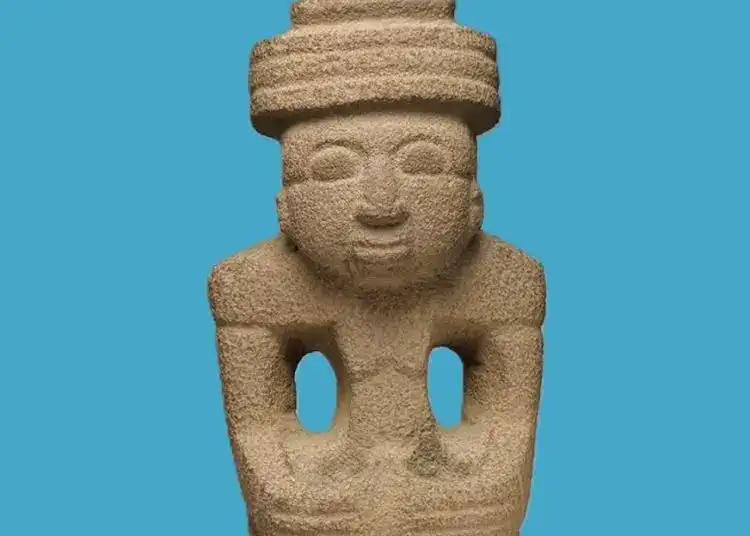 Arte prehispánico de Mesoamérica, escultura en piedra con figura humana y accesorios tradicionales, representando cultura indígena y tradiciones ancestrales en México. – SoyMigrante.com REVISTA